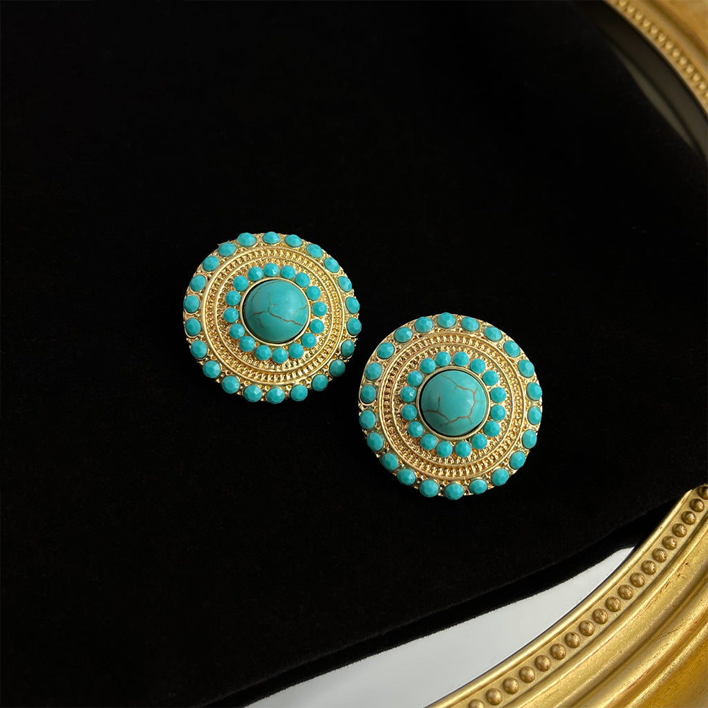 Artistic vintage turquoise earrings with silver needle posts and geometric patterns, showcasing heavy craftsmanship and retro luxury.