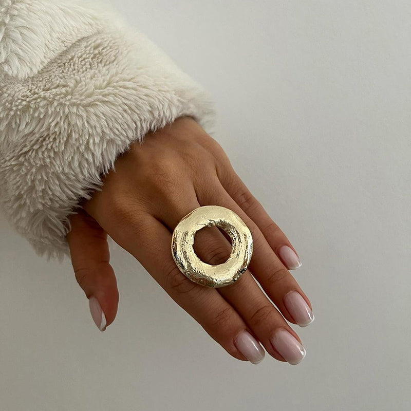 Gold donut-shaped ring with a textured surface.