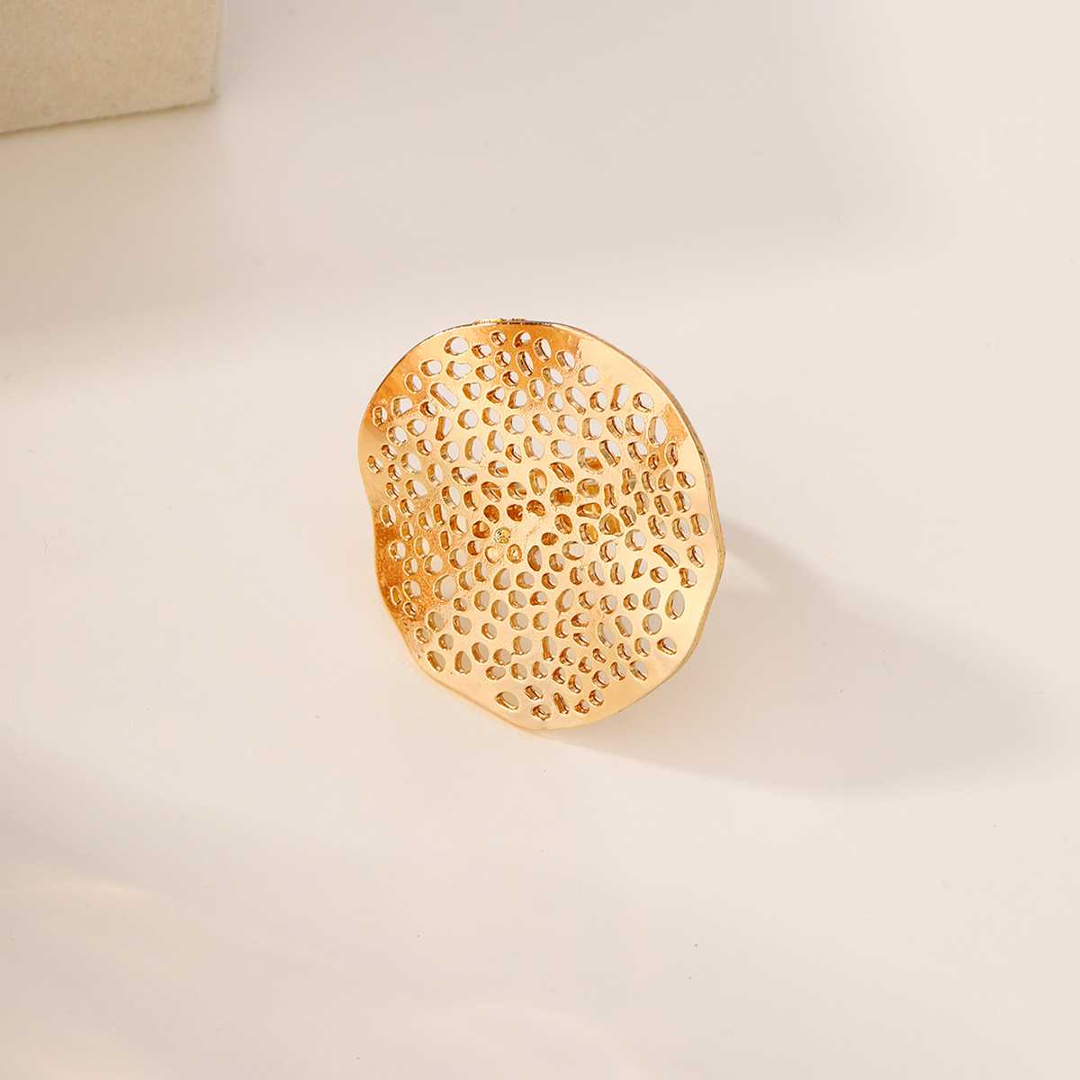 Gold honeycomb-patterned ring with a central white pearl.