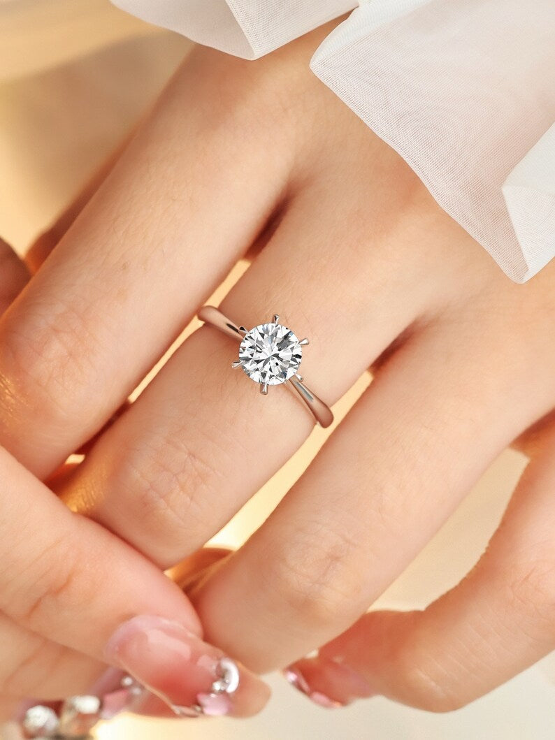 A minimalist classic 6-prong lab-grown round diamond engagement ring with a hidden halo