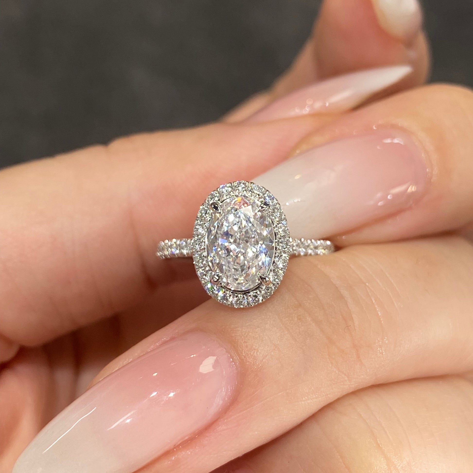 Oval Halo Lab Grown Diamond Engagement Ring in 18K White Gold, featuring a brilliant oval diamond surrounded by a halo with pave setting.